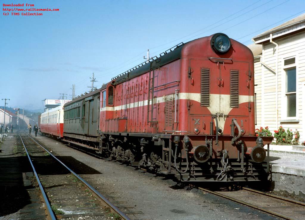 X1 places the carriage stock (DB-ACS-ABD) at the platform at Devonport station in preparation for a day excursion to Deloraine (behind H5) and Mole Creek (behind CCS25) on 7 March 1964